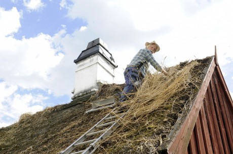 Ingmar Melin från Knadriks Kulturbygg på smedjans tak. Foto: Viveca Ohlsson/Kulturen