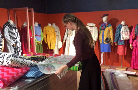 Textilkonservator Cajsa Hallberg monterar kläder och textilier i vår Gudrun Sjödén-utställning