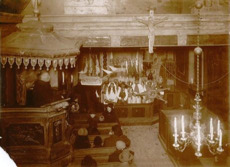 Intendent Karlin berättar om gamla julseder i Bosebo kyrka på Kulturen i Lund på trettondagen 1930. Innanför altarringen står stjärngossarna.