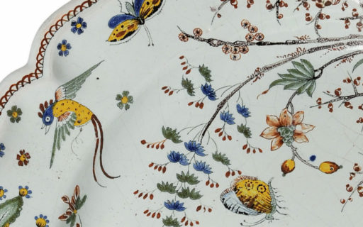 Stort franskt fat i fajans gjort 1740 i Rouend. Blomstermåleriet med fåglar visar ett tydligt inflytande från kinesiska porslinsdekorer.