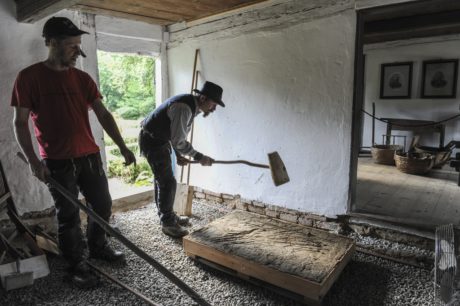  Kulturens Olof Andersson och timmermannen och arkeologen Kalle Melin bearbetar en provyta med lerpiska och lerklubba för att slå ut eventuella luftbubblor och komprimera lerskiktet. Foto: Viveca Ohlsson/Kulturen