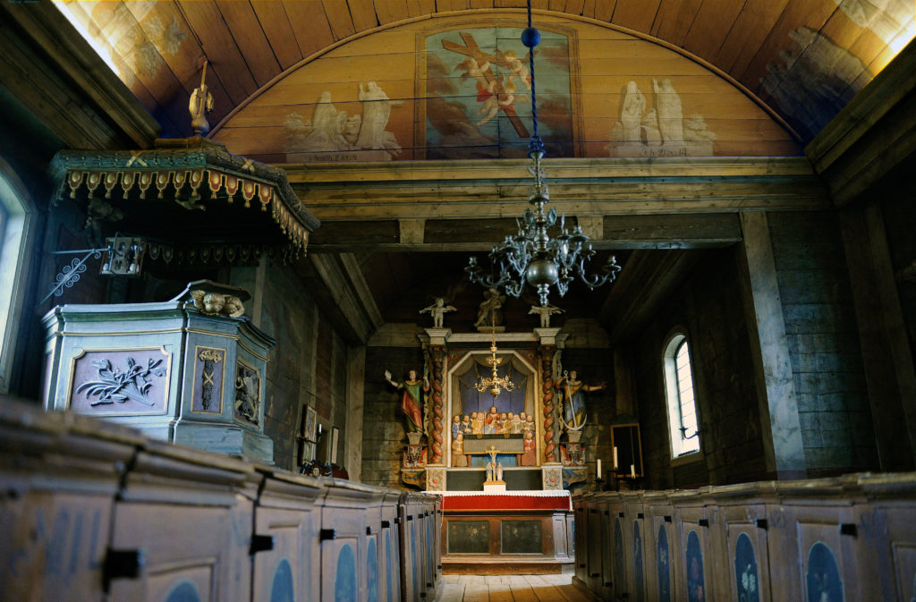 Bosebo kyrkas interiör, med predikstol och altartavla och tak- och väggmålningar från 1700-talet.