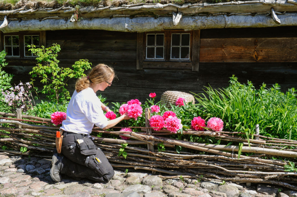 A gardener tends to to flowers outside The Blekinge Farmhouse.