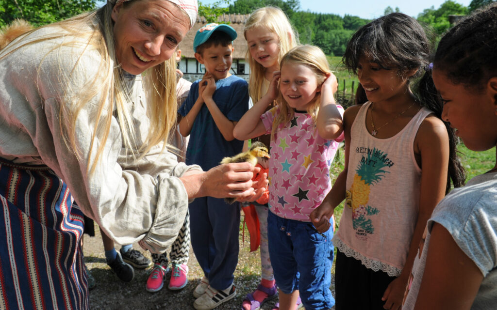Gårdsbrukare Emma Johansson har en djurvisning för en skolklass.