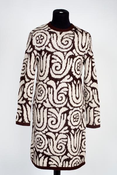 Långärmad klänning i mörkbrun och vit grovstickad ull i mönstret KURBITS. Tillverkad av MMT AB 1966.