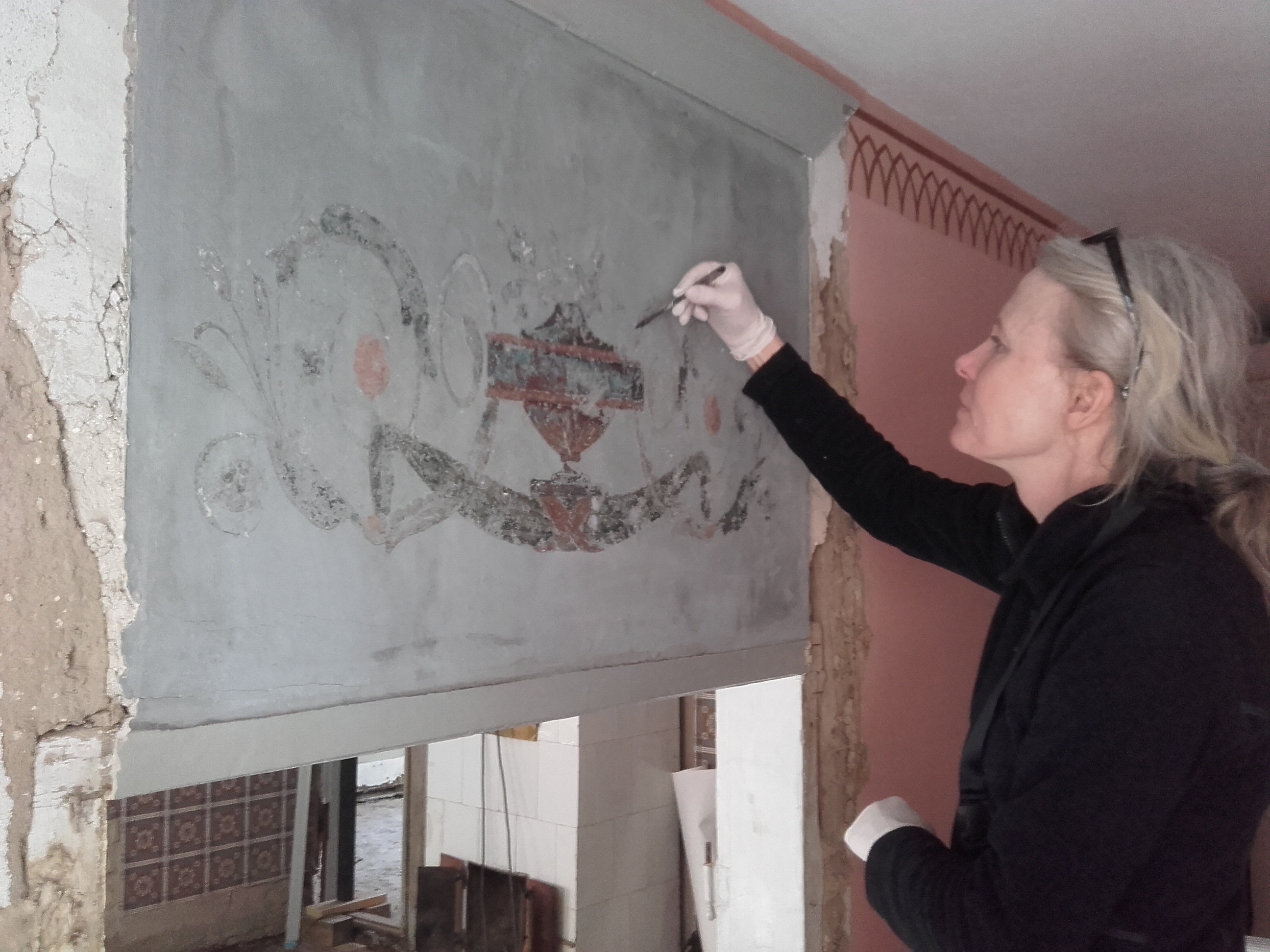  Ingrid Wedberg från Skånes Målerikonservatorer arbetar med väggmålningen i Thomanderska husets sängkammare.
