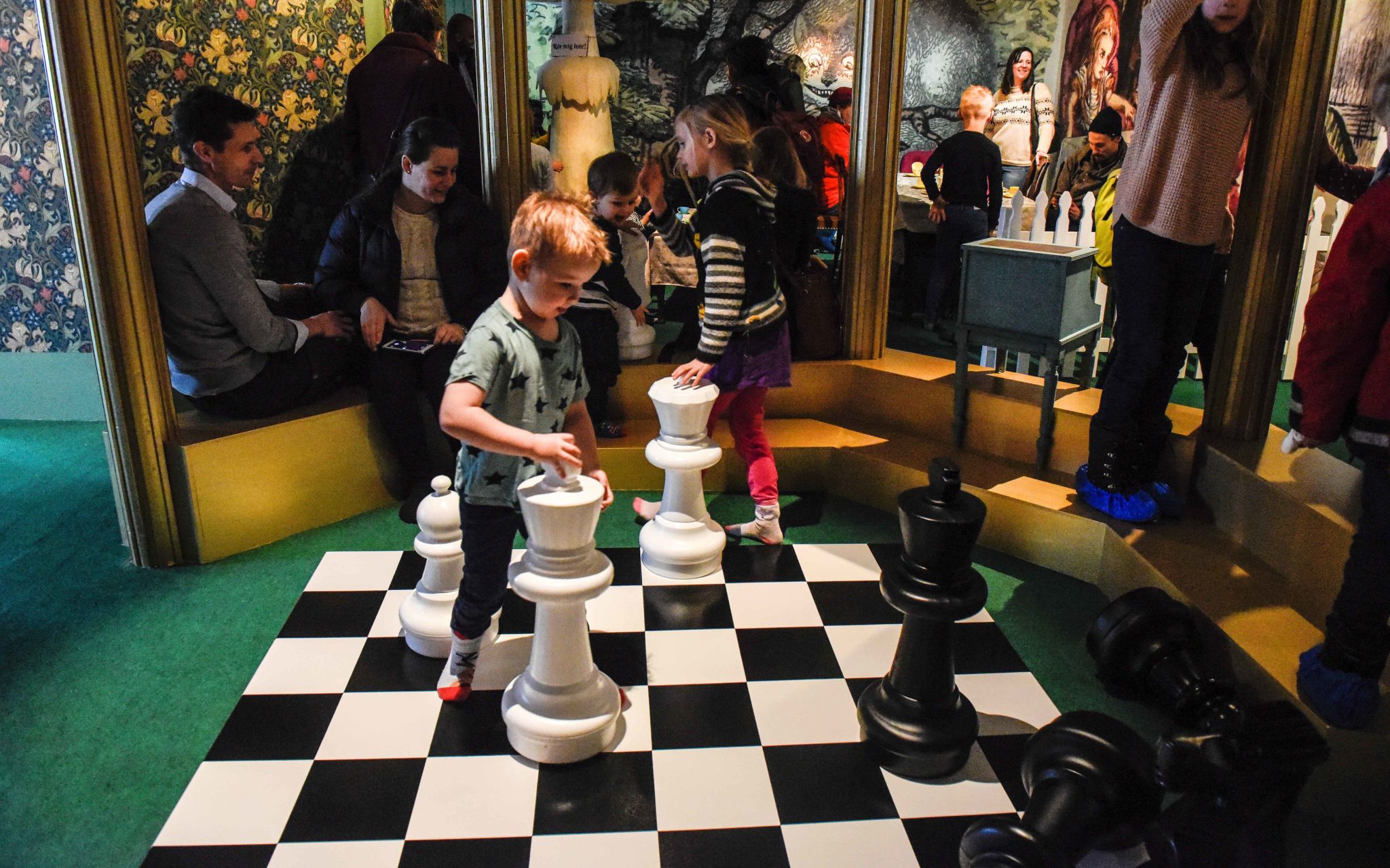 barn leker på ett stort schackbräde