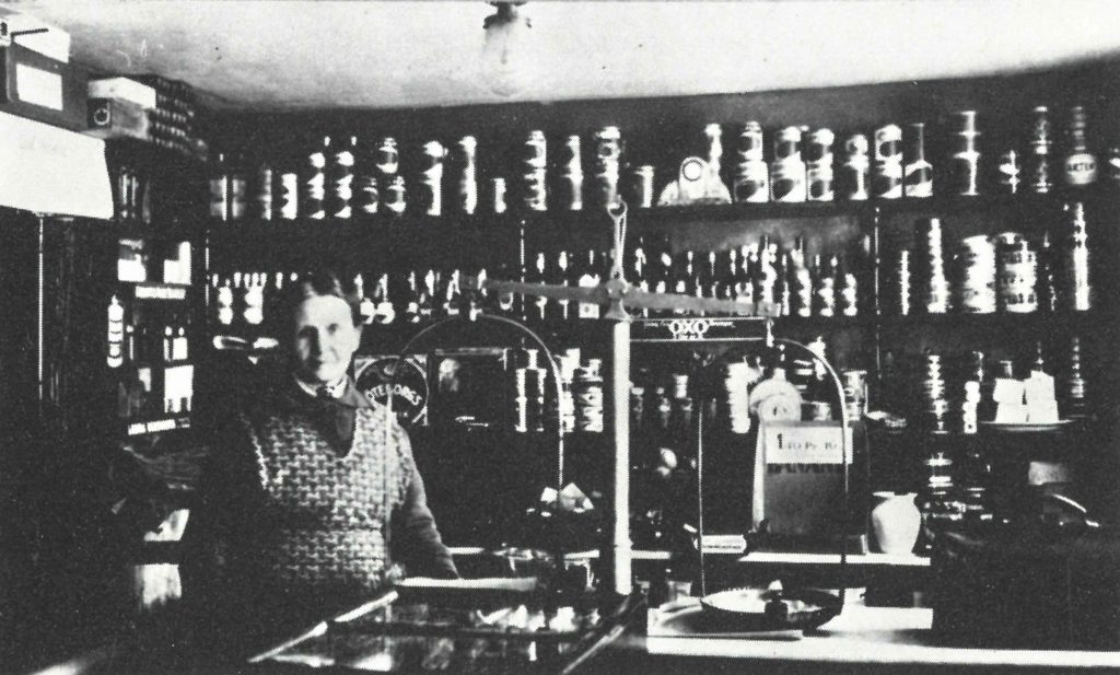 Elisabeth Larsson bakom disken i hökeriet på 1920-talet. 