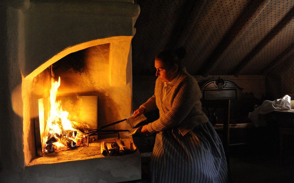 Intendent Karin Hindfelt bakar gorån över öppen eld i Bosmålatorpet.