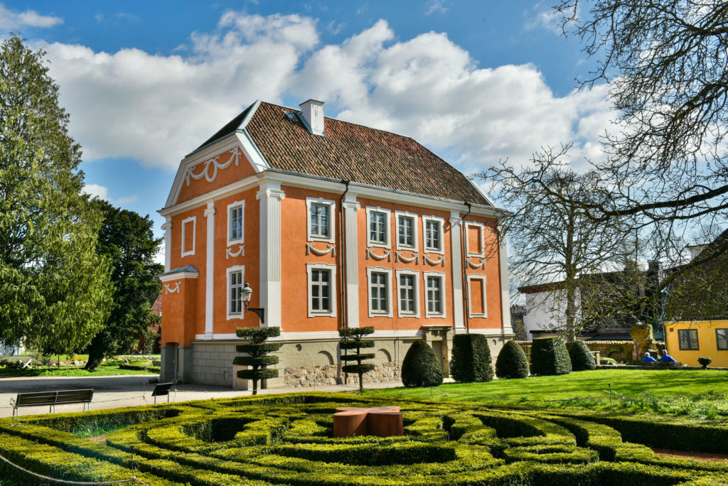 Bild på utsidan av Herrehuset med barock-inspirerad trädgård