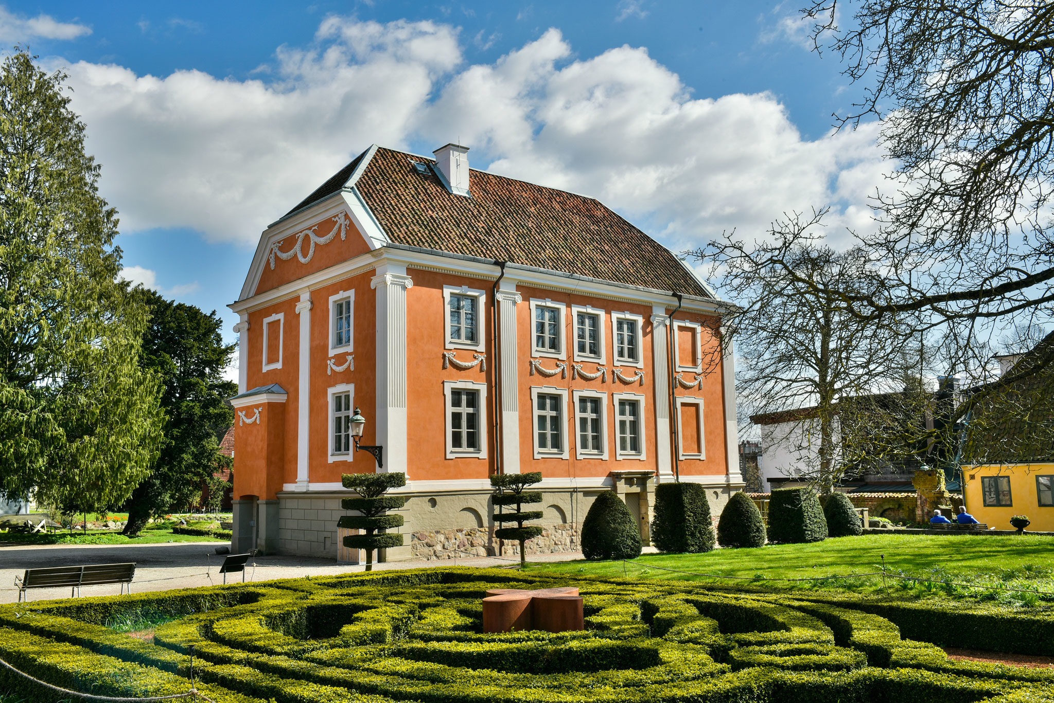 Bild på utsidan av Herrehuset med barock-inspirerad trädgård