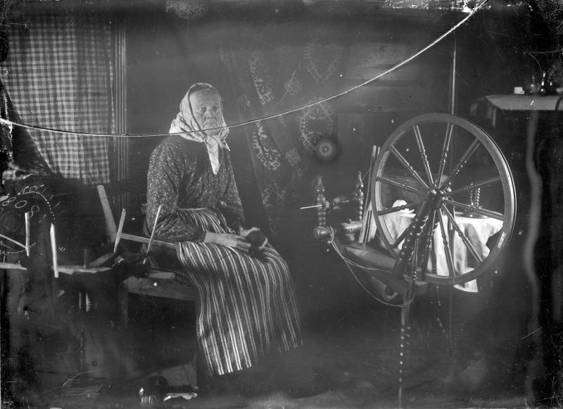 svartvitt foto av kvinna vid spinnrock