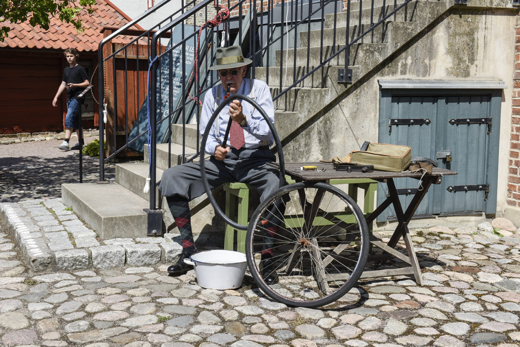 Punka på cykeln lagas på Arbetarbostadens gård av en av våra volontärer. 