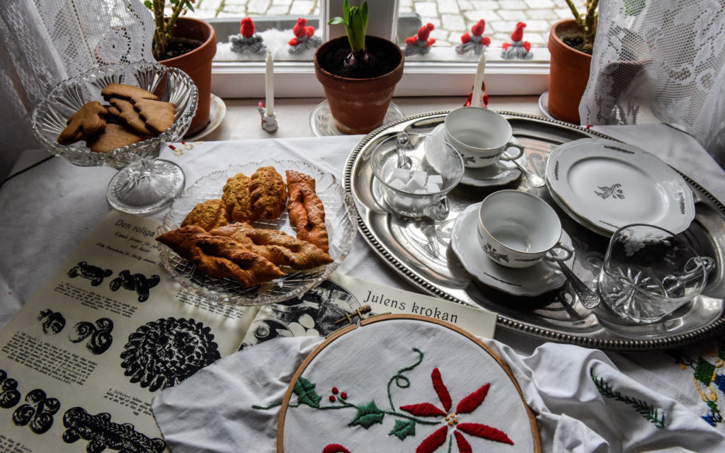 fikat står framdukat på bordet vid fönstret: mandelmusslor, klenätter och pepparkakor med kaffekoppar redo. Här ligger också ett julbroderi och jultidningar från 1930.
