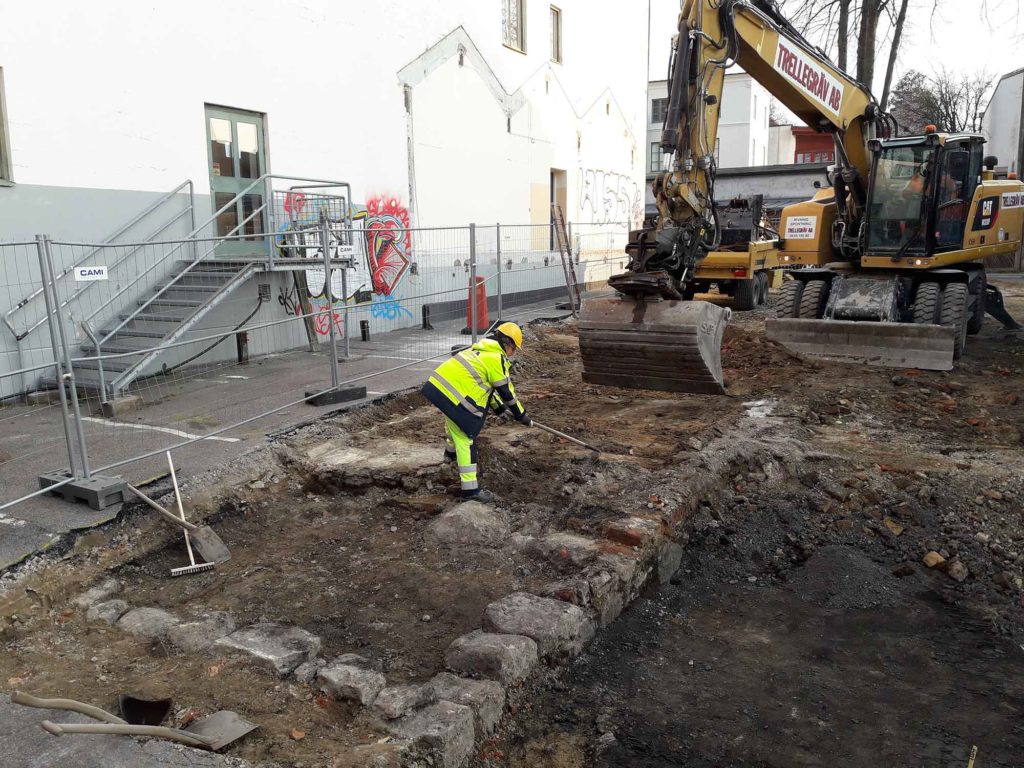 Ljusstöperiet schaktas fram. Arkeologen står precis vid platsen för en ugn, så närmast kameran är rummet där arbetet med ljusstöpningen utfördes.