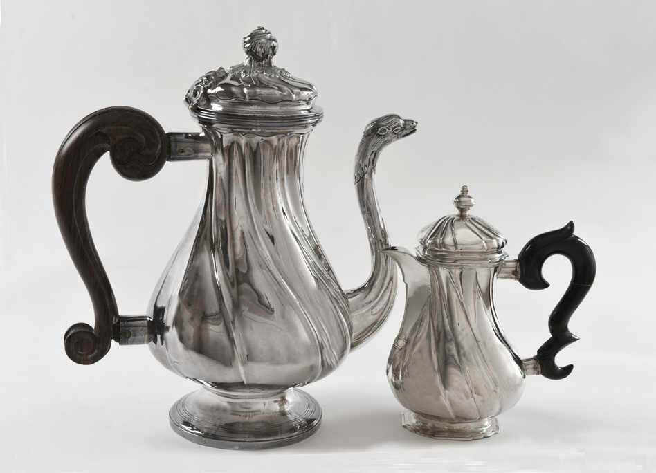 TVÅ ROKOKOKANNOR: med dekor av vridna knäckar: den stora 26,5 cm och med pip från Turin, Italien, ca 1750 stpl MC, samt den mindre 16,5 cm med snås, Holmström, Lund. Kaffekannor i litet format var inte ovanligt vid denna tid då kaffet fortfarande var mycket dyrt. KM 34664, KM 96623.