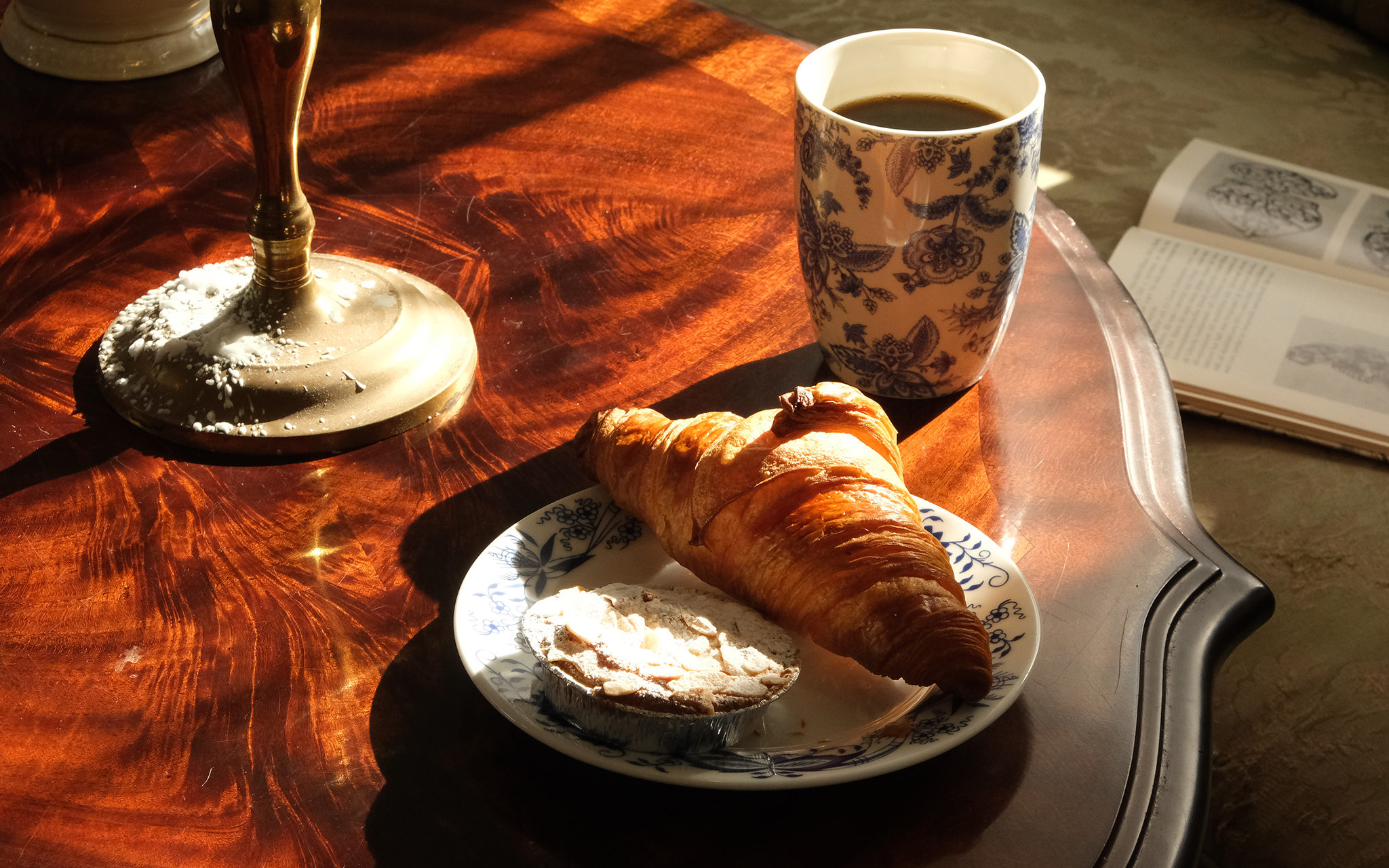 Bord med kaffekopp och assiett med croissant och citronpastej-bakelse. Foto: Jessica Ljung, Kulturen
