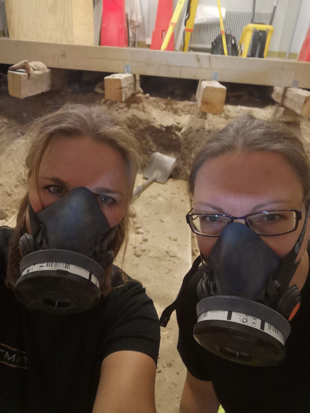 Arkeologerna Aja Guldåker och Linda Billström i skyddsmasker. Foto Kulturen. 