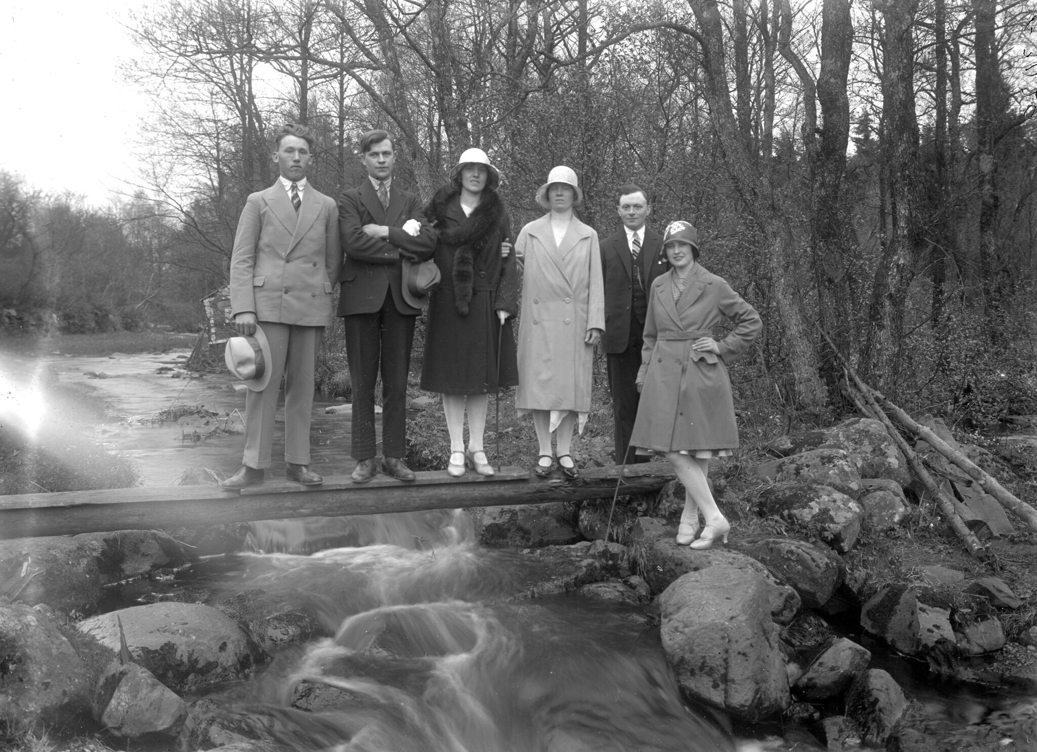 Vårpromenad vid Perstorpsbäcken, 1920-tal. Tre par poserar på en spång över bäcken. Fotografi av Per Stjernberg.
